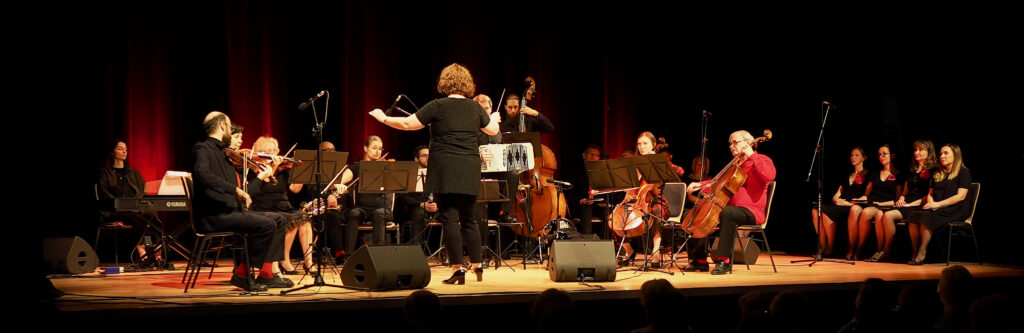 Gra orkiestra Formacji Tango Para Todos pod dyrekcją Anny Kalskiej. Z boku, na krzesłach, siedzi chór Formacji.