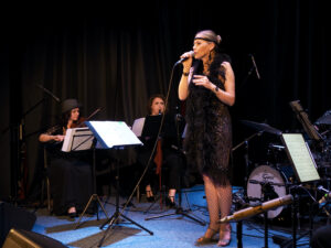 Śpiewa Monika Kwiatkowska, w tle widać skrzypaczkę i klarnecistkę
