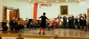 Gra i śpiewa Formacja Tango Para Todos pod dyrekcją Agnieszki Kowalskiej Wszyscy ubrani są na czarno z elementami czerwonymi.