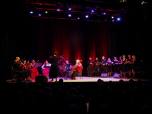 Na scenie gra i śpiewa chór i orkiestra Formacji Tango Para Todos. Dyryguje, odwrócona tyłem do publiczności, Agnieszka Kowalska.