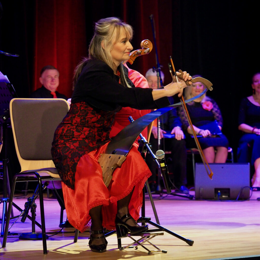 Na pile gra ubrana w czerwoną spódnicę i czarną bluzkę Jolanta Kula