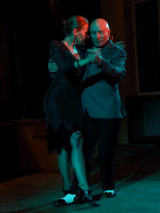 Na scenie śpiewa wokalistka, w tle kontrabasista i akordeonista